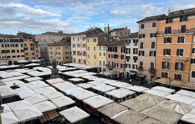 Immagine di piazza con mercato con edifici sullo sfondo